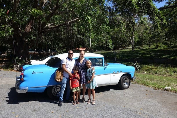 familia-viajeros-en-auto-clasico-en-soroa-cuba familia-viajeros-en-auto-clasico-en-soroa-cuba